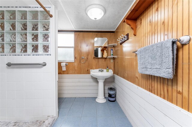 bathroom with wooden walls and tile patterned flooring