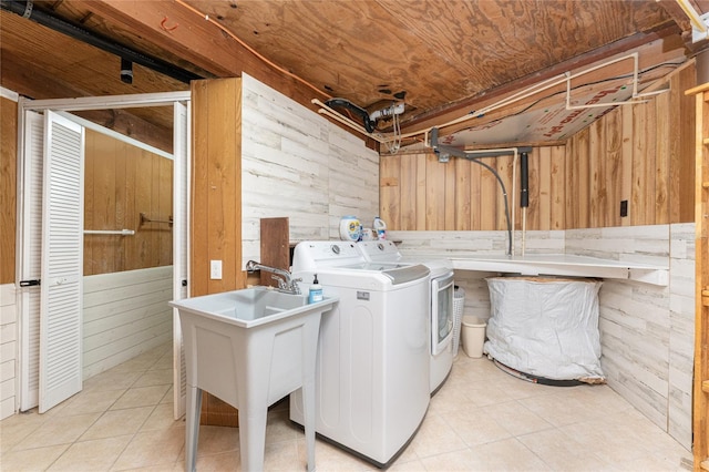 clothes washing area featuring separate washer and dryer, wood walls, light tile patterned flooring, and wooden ceiling