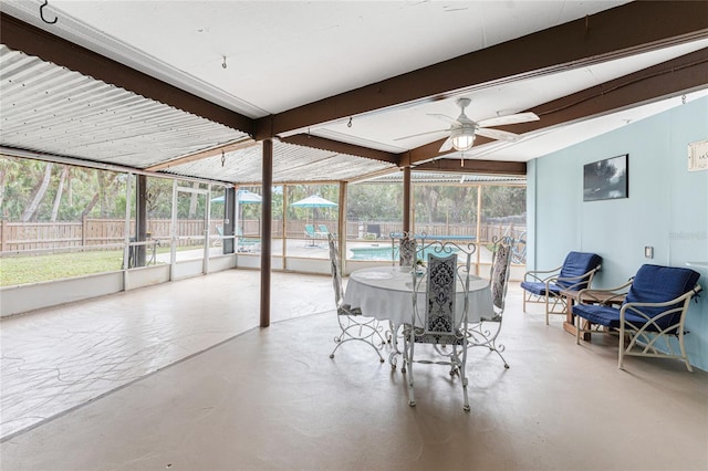 sunroom / solarium with beamed ceiling, ceiling fan, and a healthy amount of sunlight