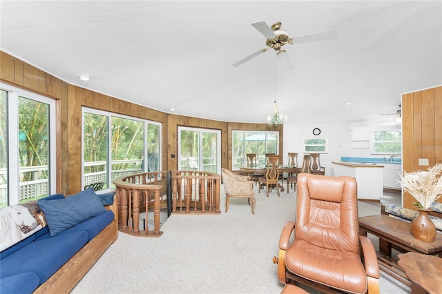 6341 Biggs St, Englewood, FL 34224 - carpeted living room with a ceiling fan, healthy amount of natural light, and wood walls