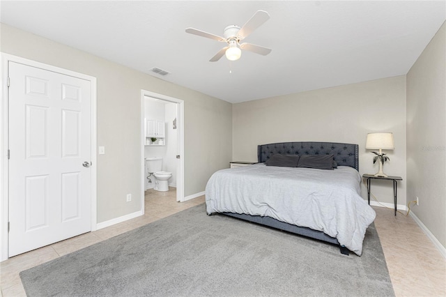 tiled bedroom with ceiling fan and connected bathroom