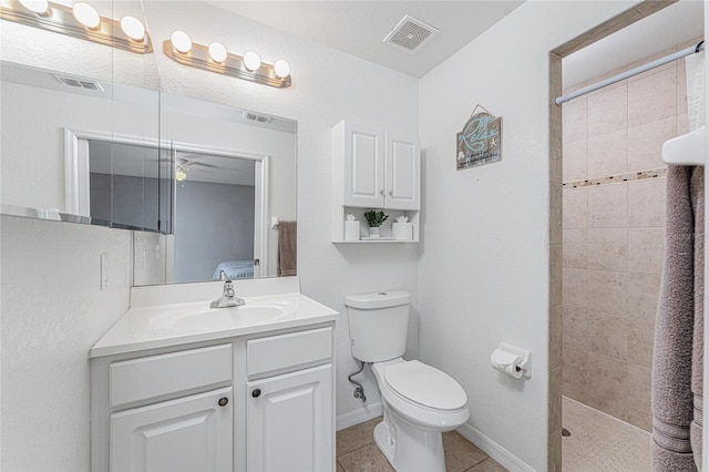 bathroom with vanity, tile patterned floors, ceiling fan, toilet, and a tile shower