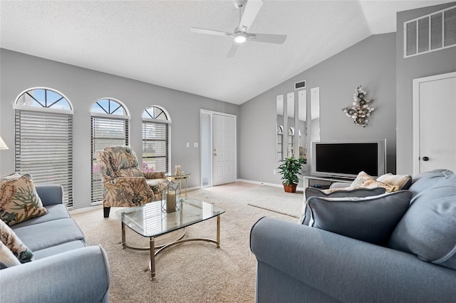 carpeted living room featuring a textured ceiling, vaulted ceiling, and ceiling fan