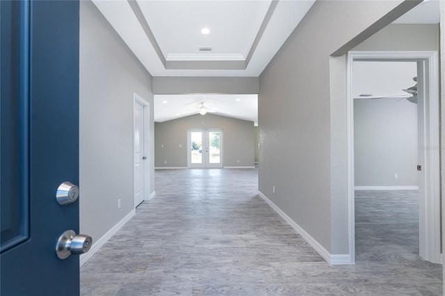 hallway featuring light hardwood / wood-style floors, lofted ceiling, and french doors