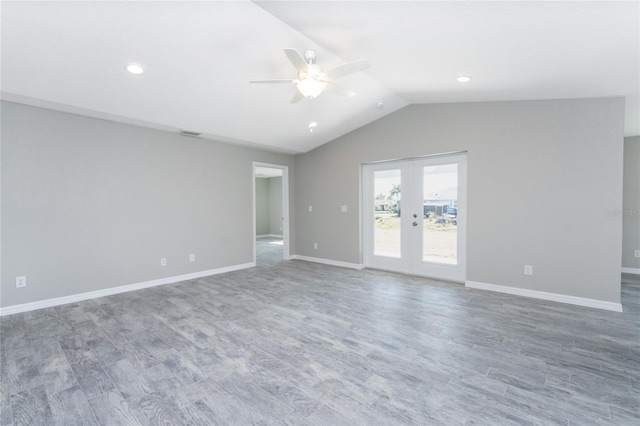 empty room featuring ceiling fan, french doors, wood-type flooring, and vaulted ceiling