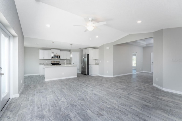 unfurnished living room featuring light hardwood / wood-style floors, ceiling fan, and a healthy amount of sunlight