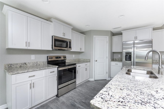 kitchen featuring dark hardwood / wood-style flooring, white cabinetry, sink, and stainless steel appliances