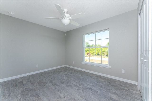 empty room featuring a textured ceiling, ceiling fan, and dark hardwood / wood-style floors