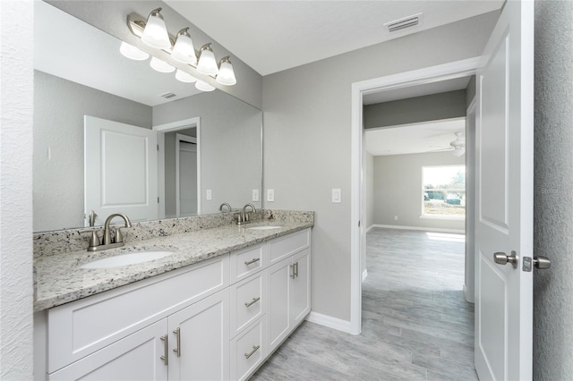 bathroom with hardwood / wood-style floors, vanity, and ceiling fan