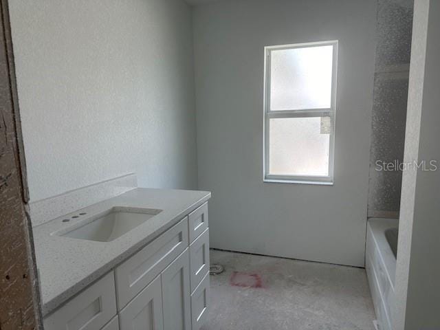 bathroom with vanity and a tub to relax in