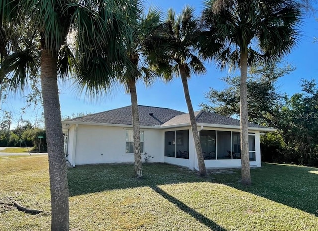 rear view of property featuring a sunroom and a yard