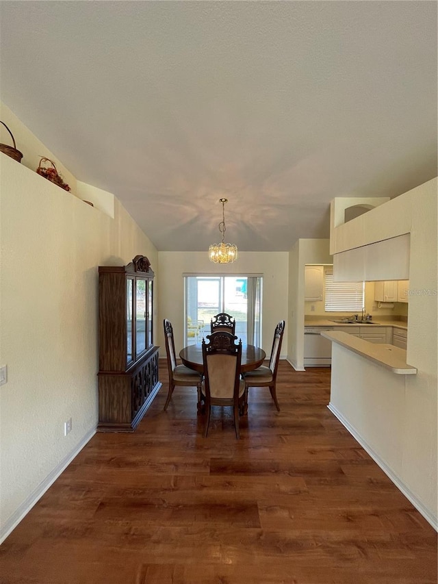 dining room featuring a chandelier, lofted ceiling, dark hardwood / wood-style floors, and sink