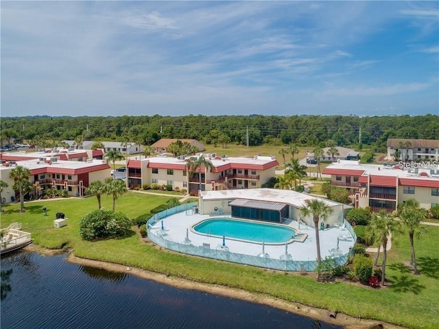 view of pool featuring a lawn and a water view