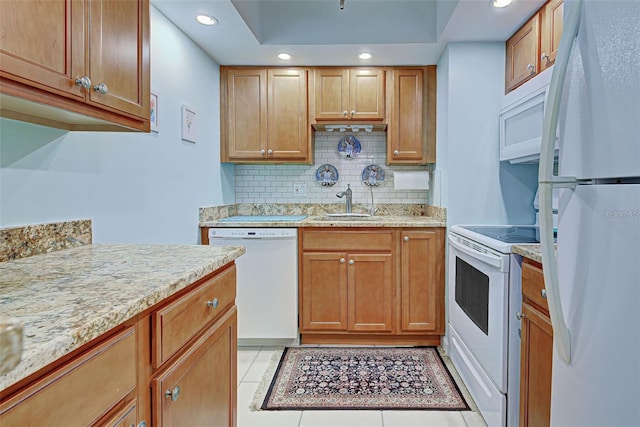 kitchen featuring white appliances, sink, light tile patterned floors, and tasteful backsplash