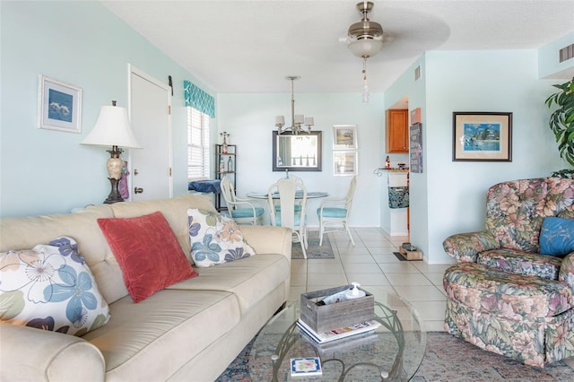 living room with ceiling fan, light tile patterned floors, and a textured ceiling