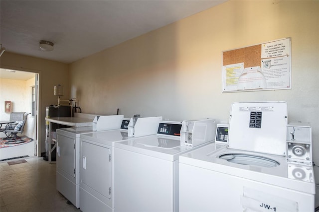 clothes washing area featuring independent washer and dryer and water heater