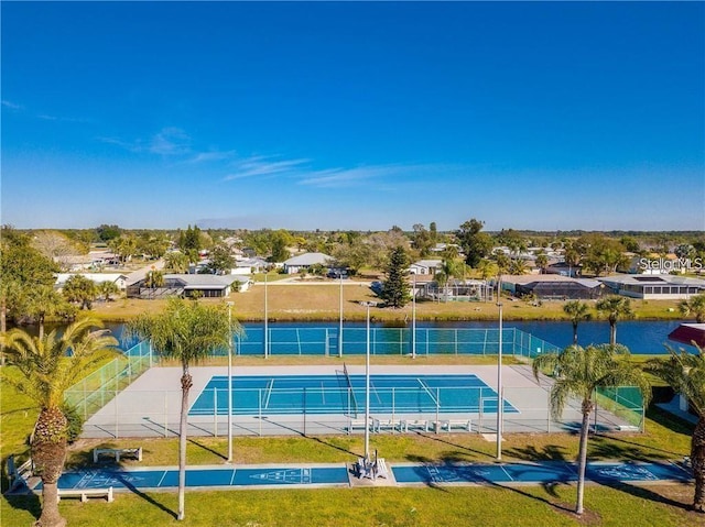 view of tennis court with a water view