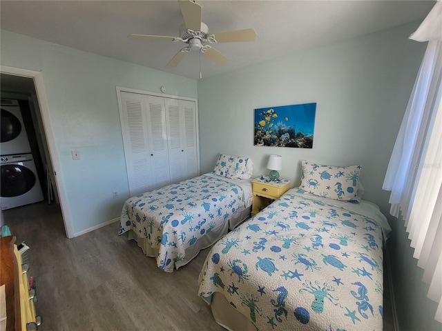 bedroom featuring ceiling fan, wood-type flooring, stacked washing maching and dryer, and a closet