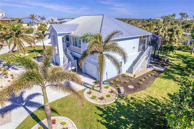 13104 Via Cassia, Placida, FL 33946 - view of home's exterior featuring stairs, a standing seam roof, and a lawn