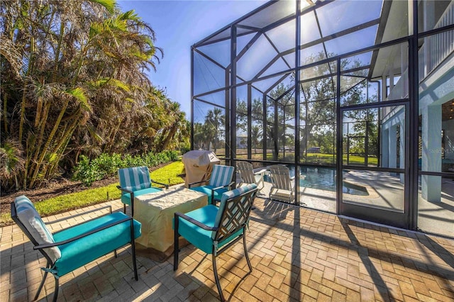 view of patio / terrace featuring glass enclosure and a grill