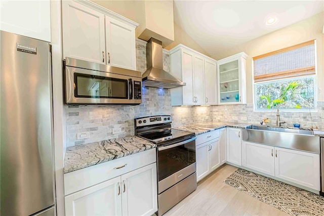 13104 Via Cassia, Placida, FL 33946 - kitchen with stainless steel appliances, wall chimney range hood, white cabinetry, glass insert cabinets, and tasteful backsplash