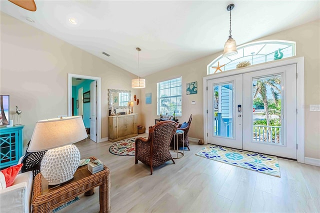 entryway with french doors, lofted ceiling, and light hardwood / wood-style flooring