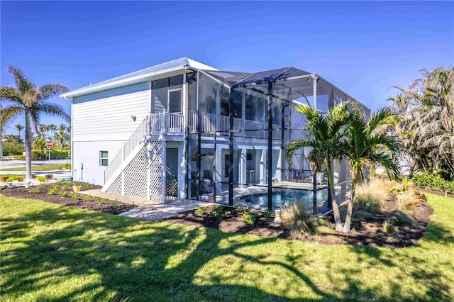 rear view of house featuring glass enclosure and a lawn