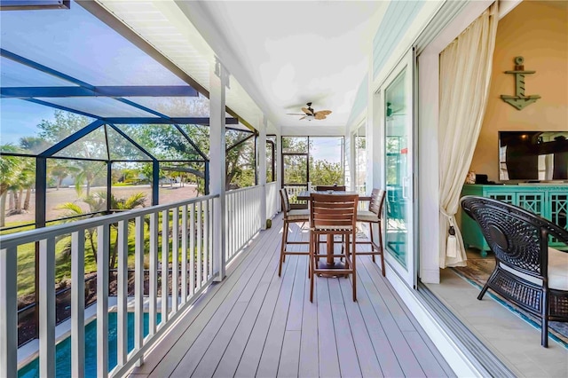 wooden deck featuring ceiling fan, a lanai, and a patio