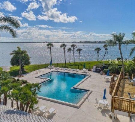 view of swimming pool with a patio area and a water view