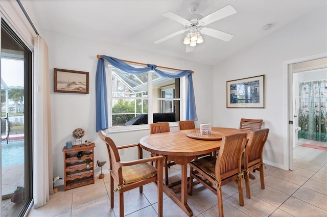 tiled dining space featuring lofted ceiling, ceiling fan, and a healthy amount of sunlight