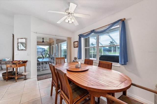 dining space with ceiling fan, light tile patterned flooring, and vaulted ceiling