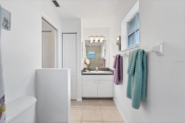 bathroom featuring tile patterned floors, vanity, toilet, and a shower with shower door