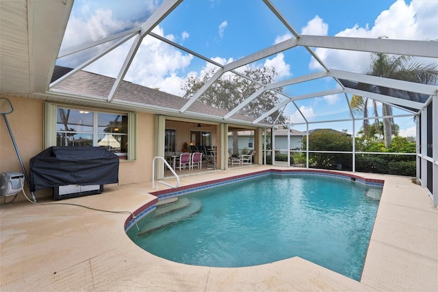 view of pool featuring a patio area, area for grilling, and glass enclosure