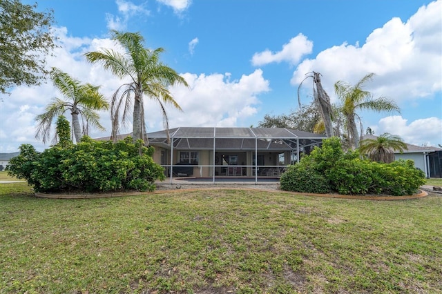 back of property with a lanai and a lawn