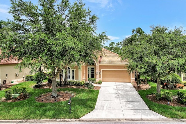 view of property hidden behind natural elements with a garage and a front lawn