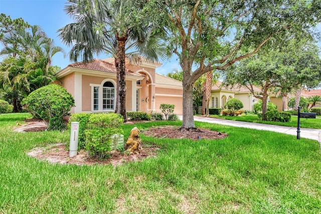 mediterranean / spanish-style house featuring a front lawn