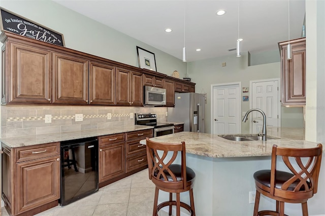 kitchen featuring light stone countertops, sink, a breakfast bar area, light tile patterned floors, and appliances with stainless steel finishes