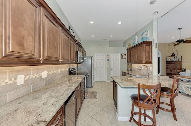 kitchen featuring sink, stainless steel appliances, tasteful backsplash, pendant lighting, and a breakfast bar