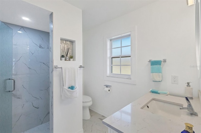 bathroom featuring a shower with door, vanity, and toilet