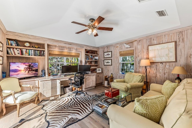 office area with plenty of natural light, built in shelves, and vaulted ceiling