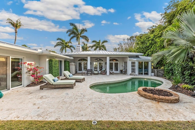 view of swimming pool with ceiling fan, french doors, and a patio