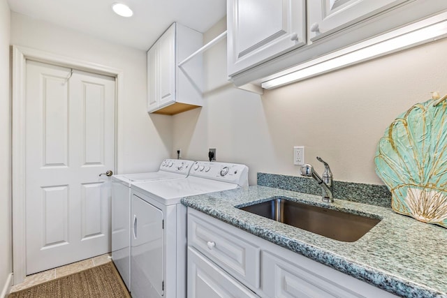 clothes washing area with washing machine and dryer, sink, cabinets, and tile patterned flooring