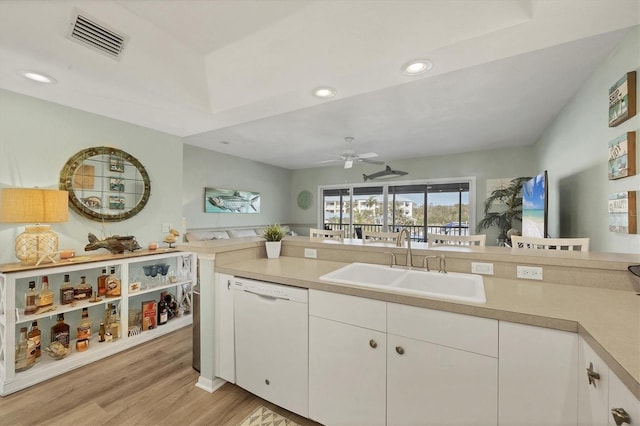 kitchen with white cabinetry, sink, white dishwasher, and light wood-type flooring