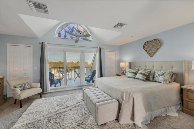 carpeted bedroom featuring access to outside, vaulted ceiling, and a closet