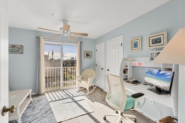 office area featuring light carpet and ceiling fan