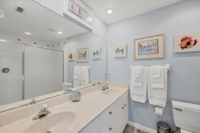 bathroom with hardwood / wood-style floors, vanity, toilet, and a shower with shower door