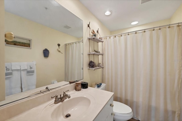 bathroom with curtained shower, vanity, and toilet