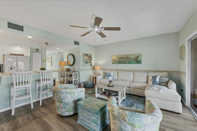 living area featuring ceiling fan, wood finished floors, and visible vents