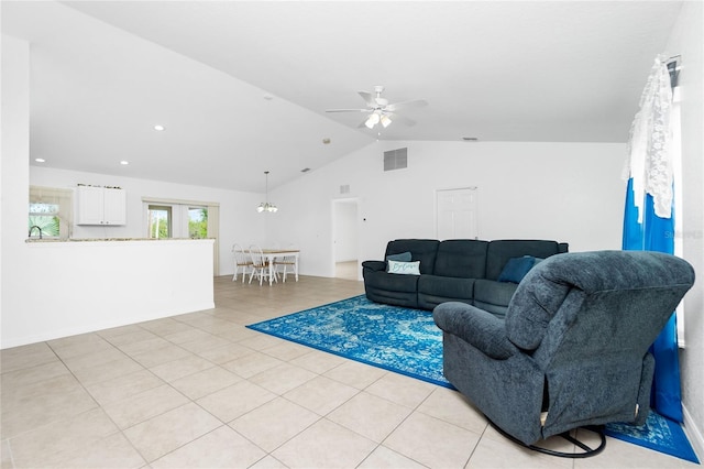 tiled living room with vaulted ceiling and ceiling fan with notable chandelier