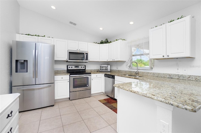 kitchen with lofted ceiling, sink, white cabinets, and appliances with stainless steel finishes